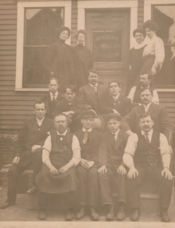 Posed image of the staff of Le Messager on the steps of their office building, including Camille Lessard Bissonette. 15 staff members of Le Messager pose on the steps of their office building. All are well dressed for the picture. 11 are men, and 4 are women, the women standing closest to the door of the office, and the men sitting on the steps.